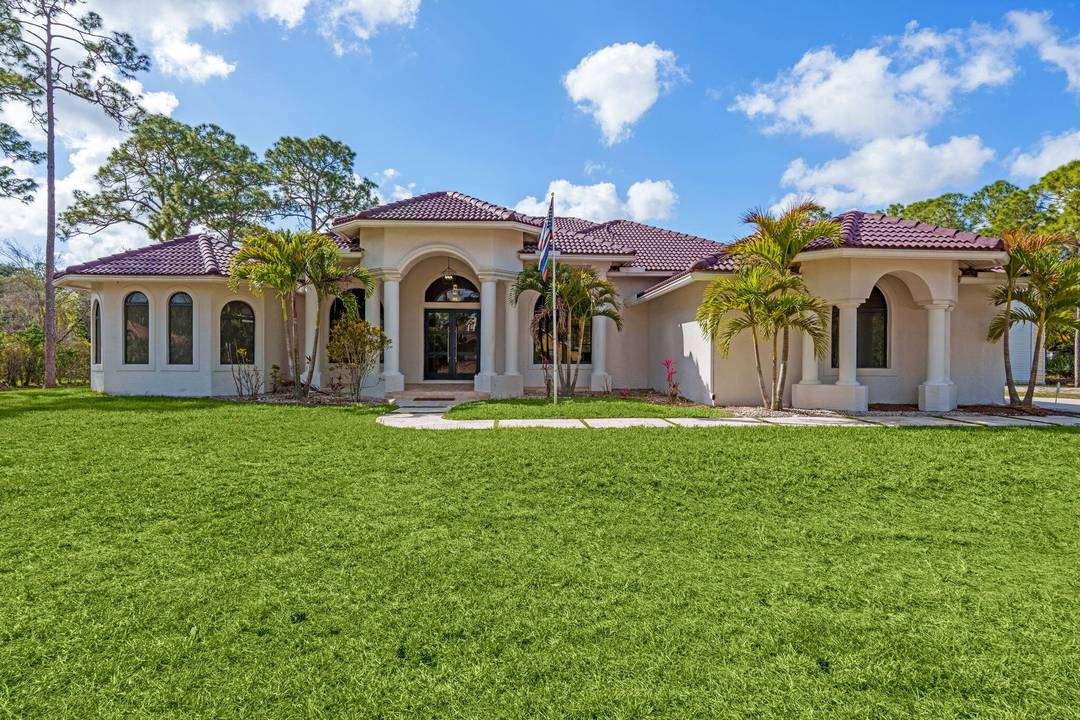 Welcome to this home in The Acreage, offering 4 bedrooms plus a den, 3 full bathrooms, and a half bath, all set on an expansive 1.