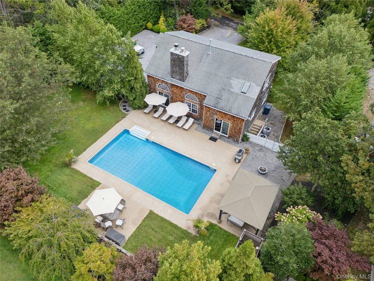 Enjoy the best of Hamptons summer living in this contemporary four bedroom home in Hampton Bays, set on nearly one acre of private, landscaped grounds.