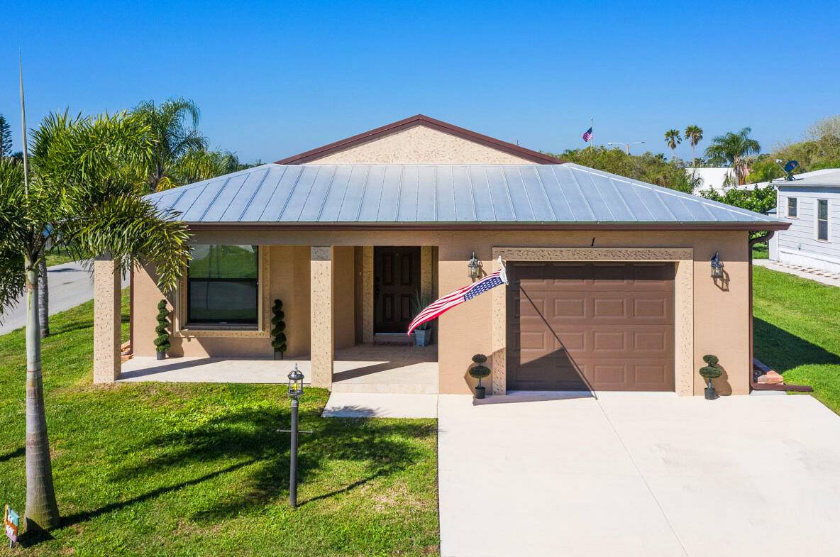 Discover true Florida living in the 2 bedroom, 2 bath Carlton model featuring a spacious layout, soaring vaulted ceilings, a covered front porch, and attached garage.