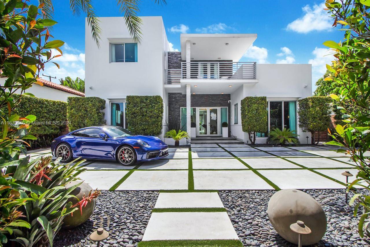 Contemporary home in Miami Beach surrounded by lush tropical landscape and situated in front of the Golf Club.