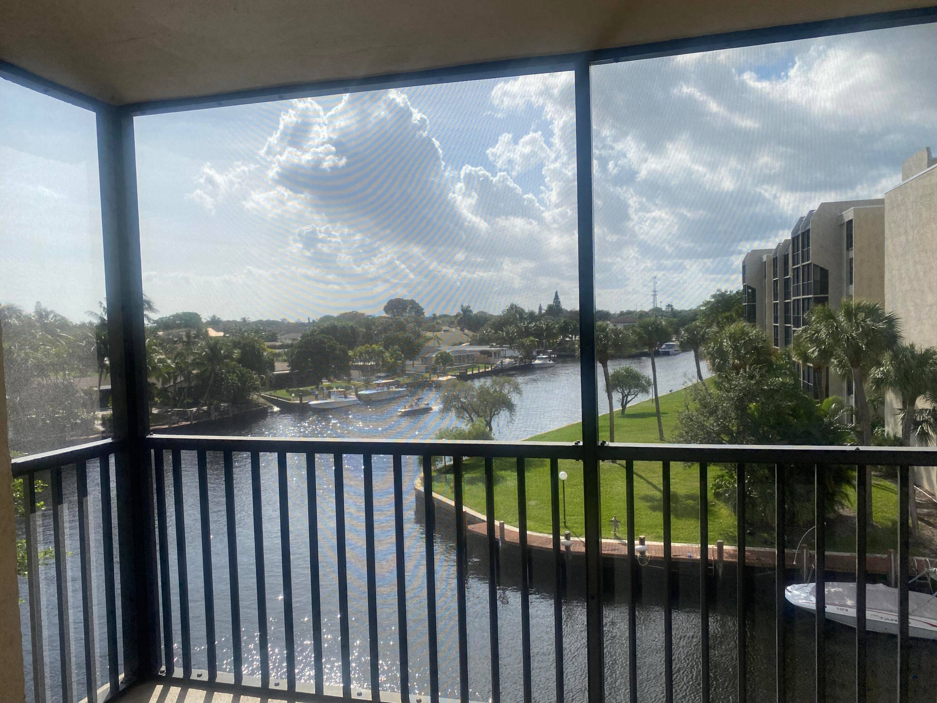 STUNNING WATER VIEWS ! Private end unit with sweeping Hillsboro Canal views from wrap around windows and screened balcony.