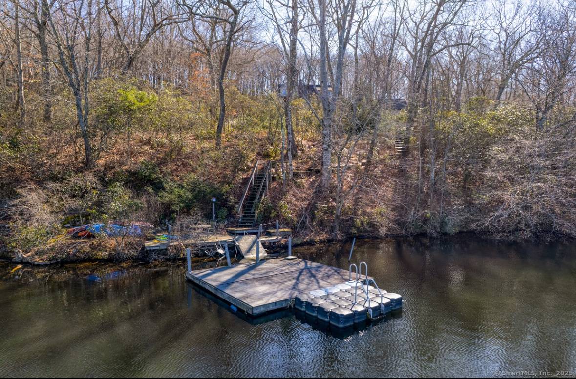 Perched on two acres of pristine lakefront property, this stunning home offers breathtaking tree top views of the water, surrounded by the tranquility of nature.