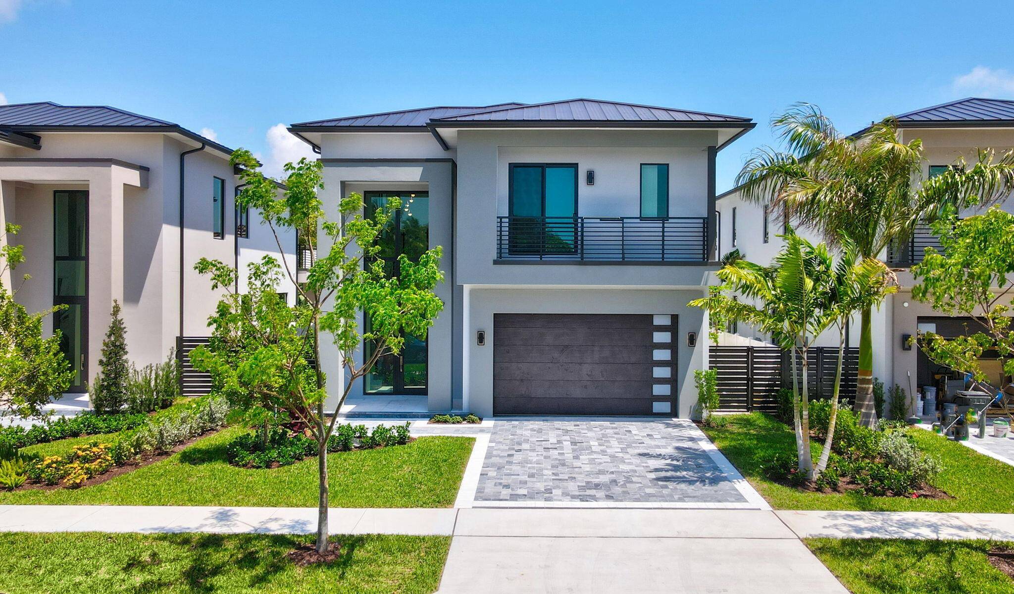 Newly constructed luxury residence with soaring ceilings, impact windows, a metal roof, and porcelain tile throughout.