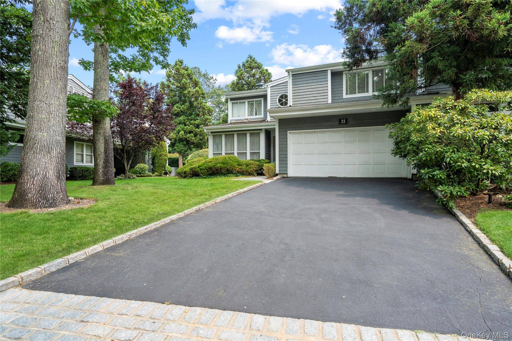 Welcome to this spacious and sun drenched corner end unit in the desirable gated community of Spruce Pond Manhasset.