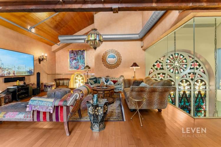 Set within a converted Romanesque Revival church, this unapologetically bold duplex penthouse is defined by dramatic architectural framework and commanding presence.
