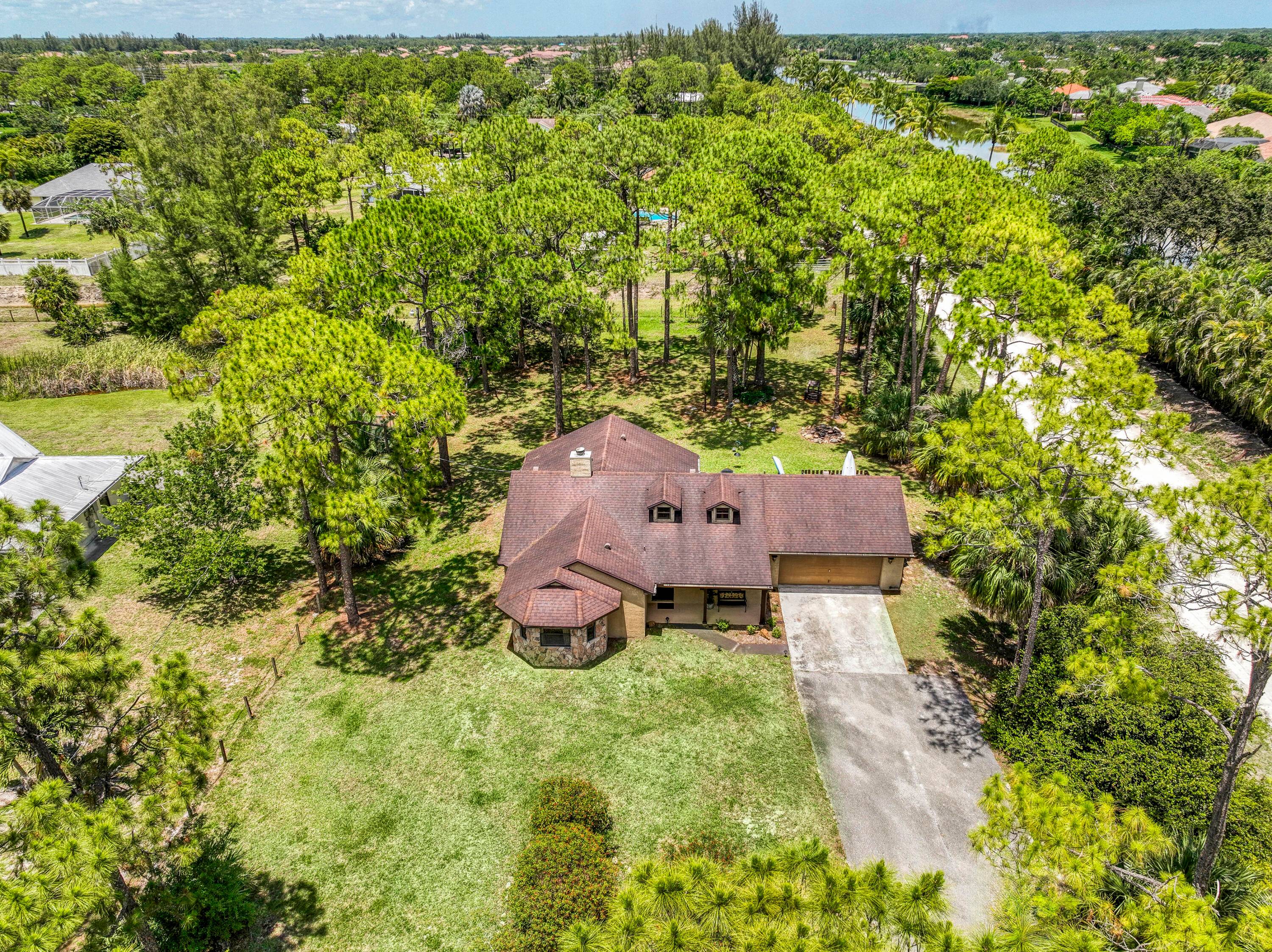Nestled on the eastern edge of The Acreage, you can find this woodsy 3 bedroom, 2 bathroom slice of tranquility and peace sitting on 1.