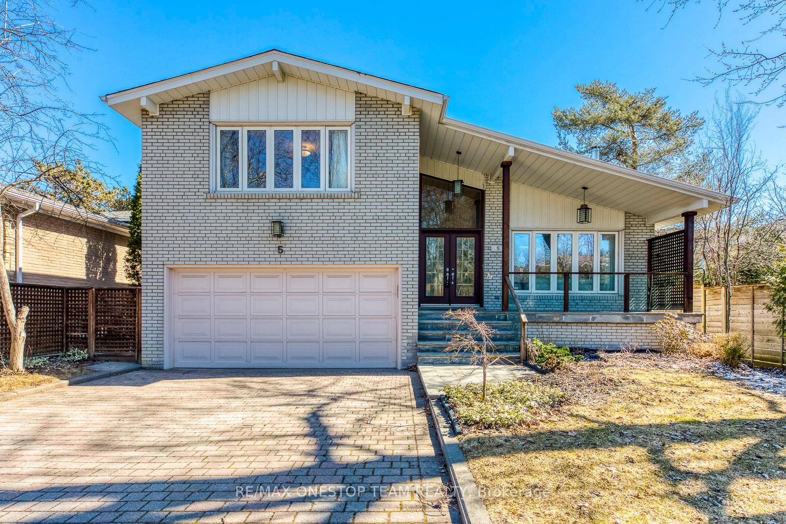 This beautiful residence boasts exceptional curb appeal with flagstone steps, a welcoming front porch, and lush, professionally landscaped grounds.