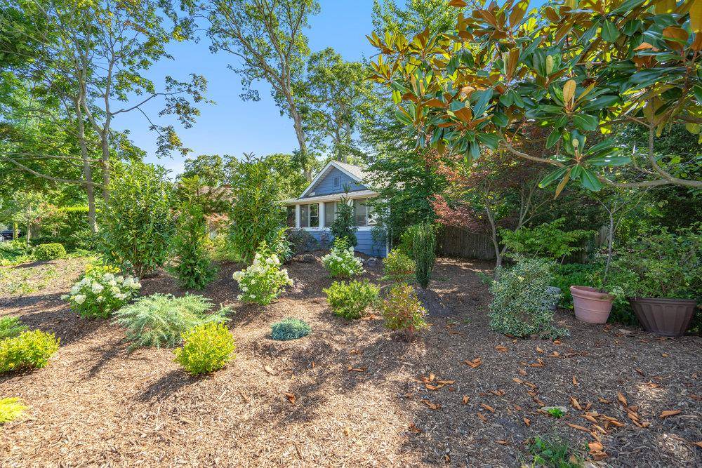 Discover a unique corner property in Brightwaters surrounded by lovingly tended gardens.