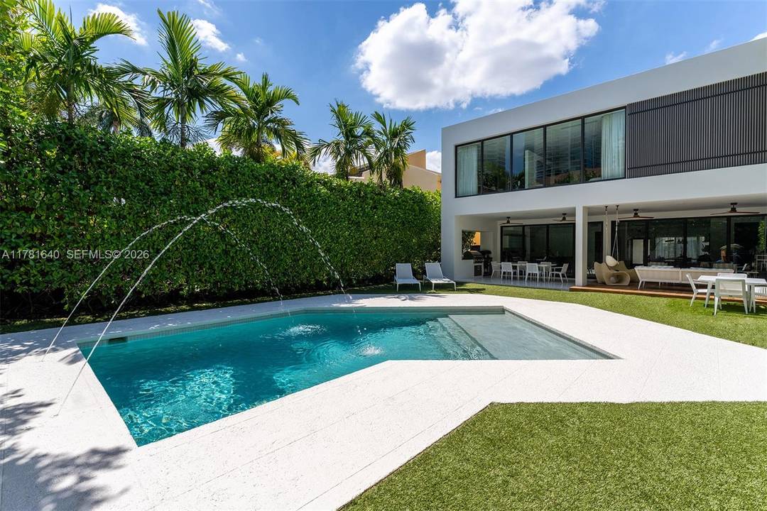 Behind a private gate, this modern home offers high ceilings, a striking open balcony, and a thoughtfully designed main level with lavish tile and wood flooring.