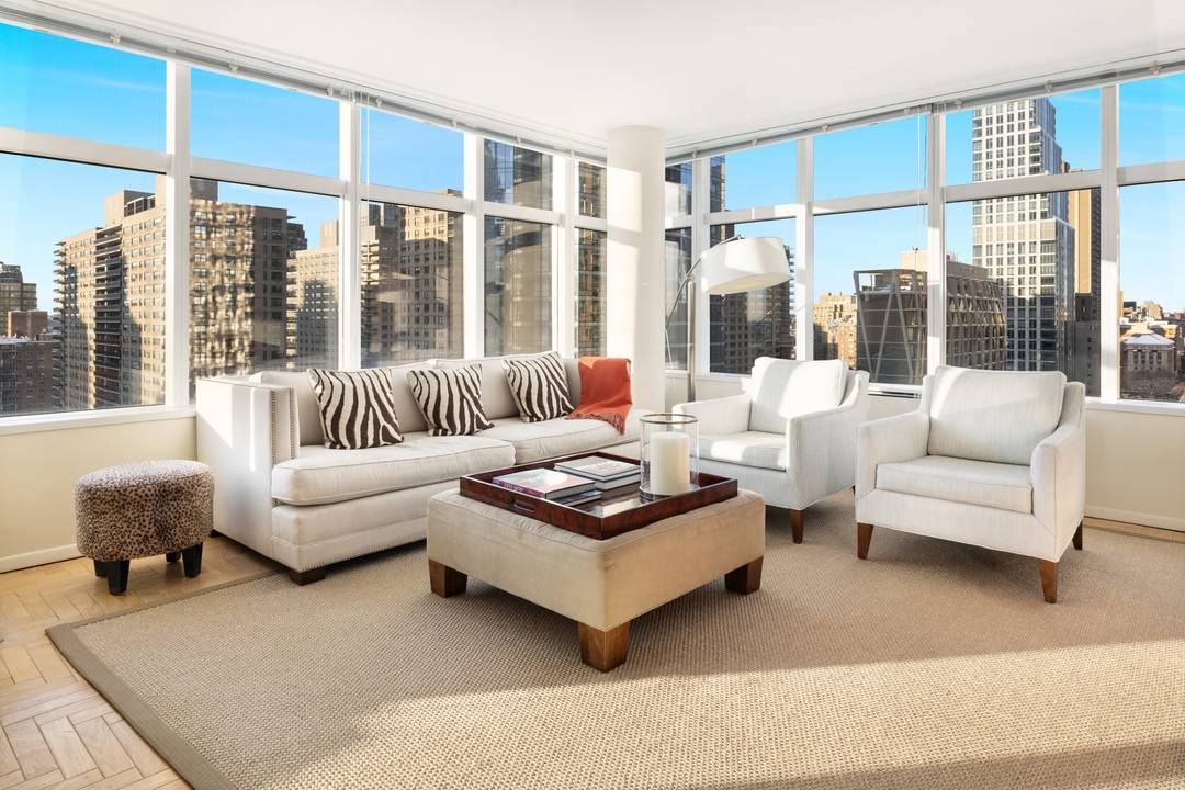 High above Lincoln Square, Residence 19B at 3 Lincoln Center enjoys sweeping views of the Hudson River and the Manhattan skyline through dramatic floor to ceiling windows.