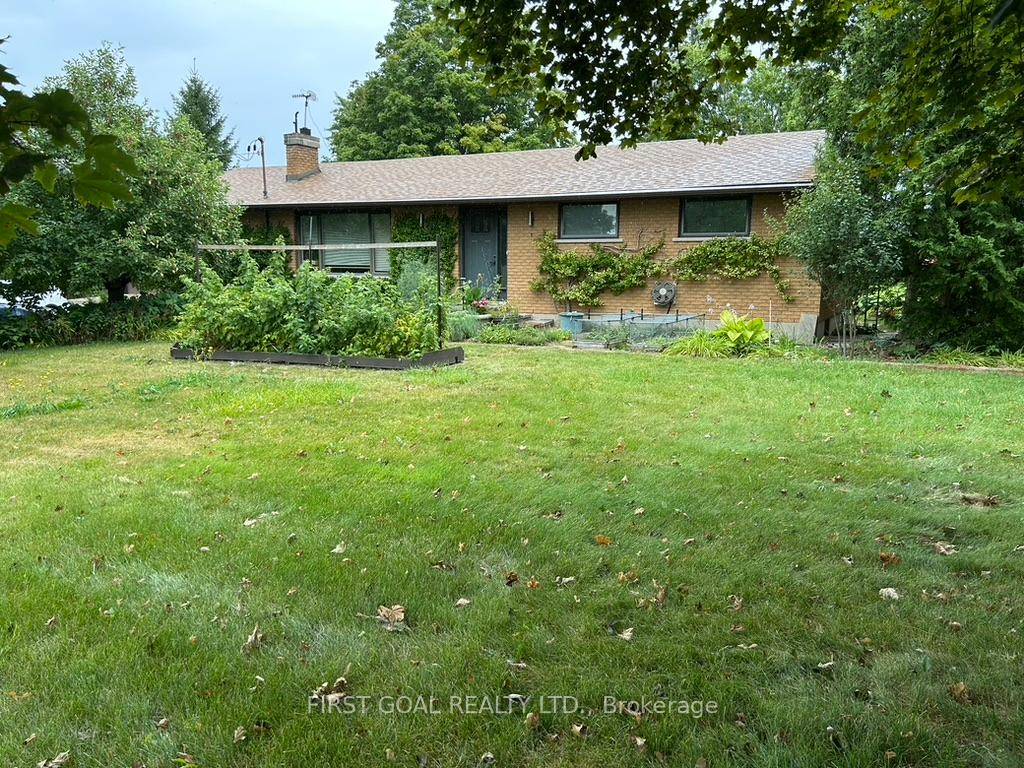 This charming brick bungalow is nestled in a beautiful country setting, surrounded by lush gardens and a serene pond.