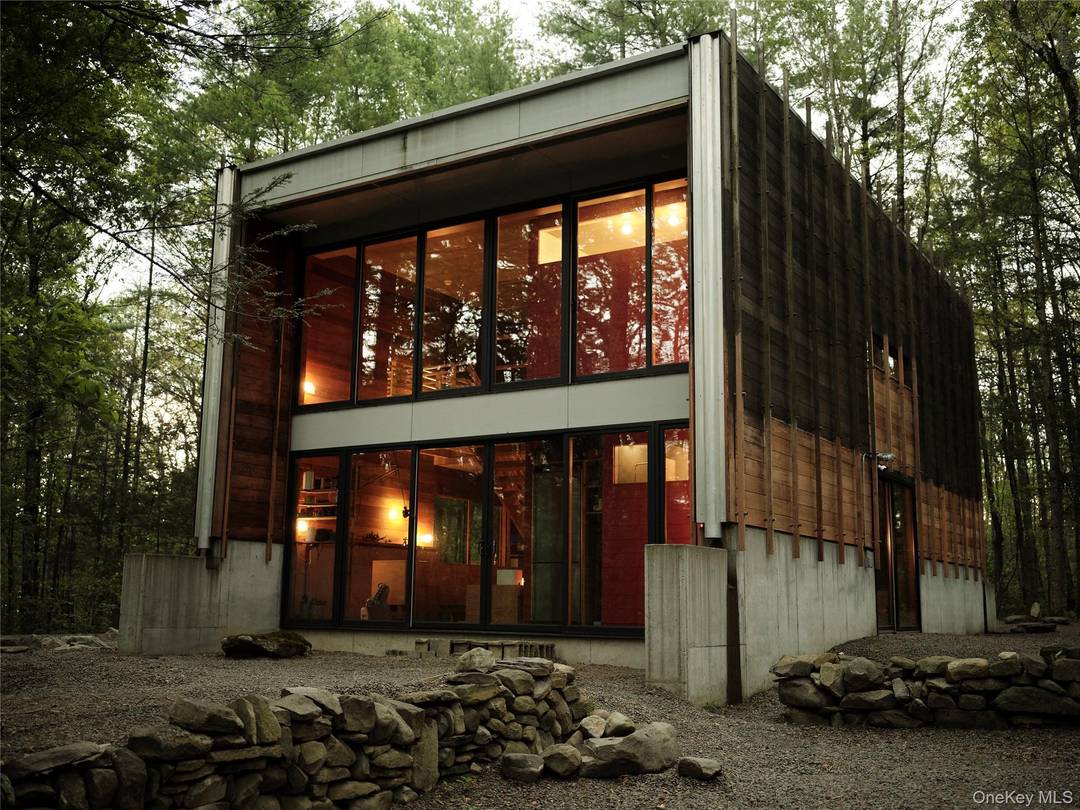 Located on 24 acres of woods, this one of a kind modern home offers a yearlong invitation to live inside a design magazine.
