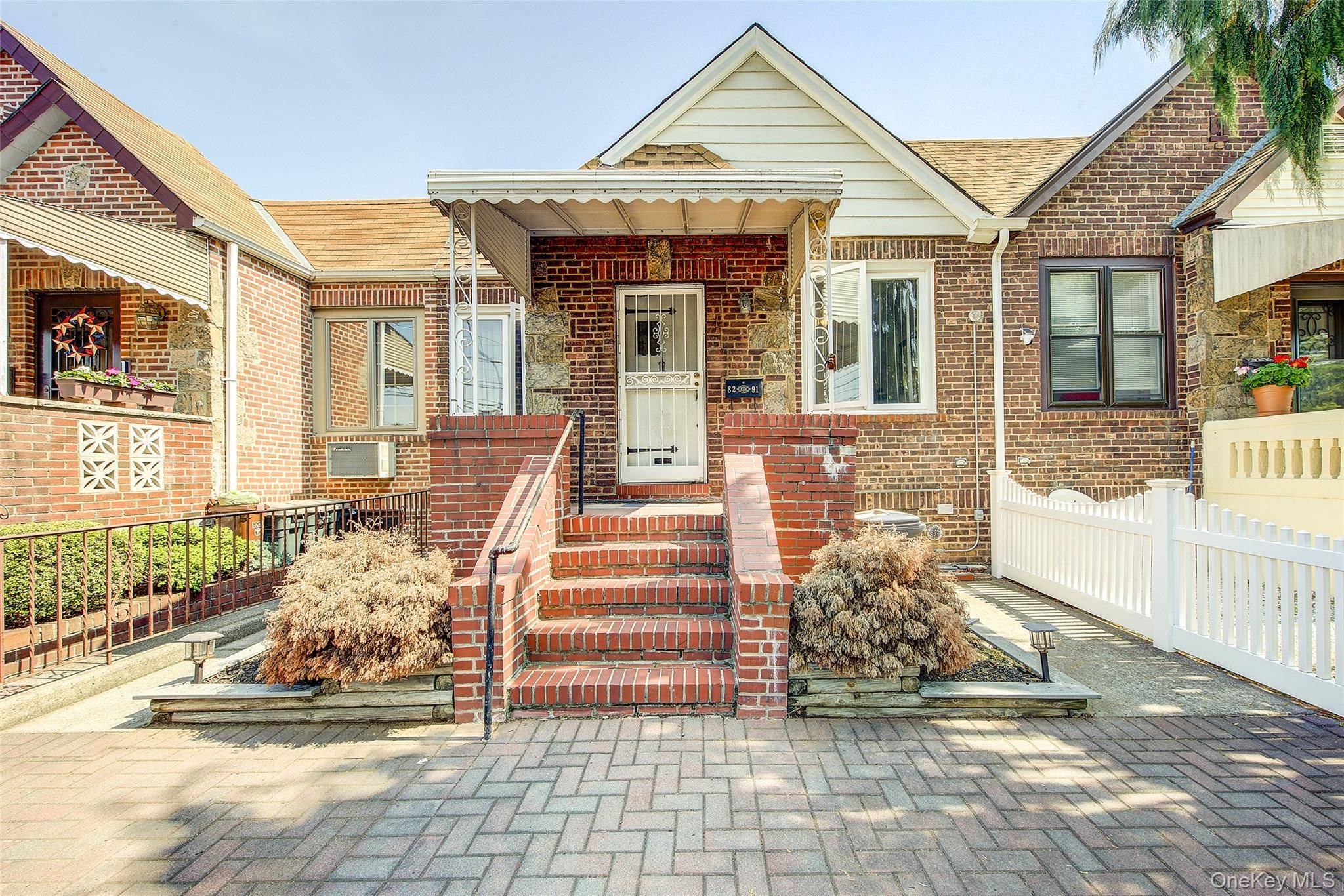 Charming single family attached home on a beautiful rowhouse block in Middle Village North.