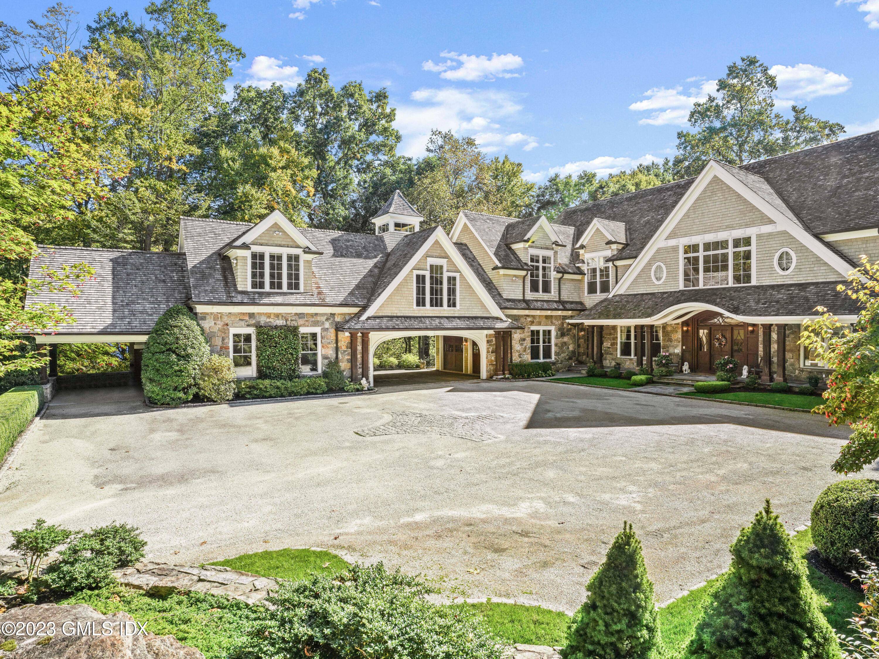 The grand courtyard approached by a sweeping tree lined drive leads to this stone and shingle masterpiece built by a premier builder known for extraordinary craftsmanship.