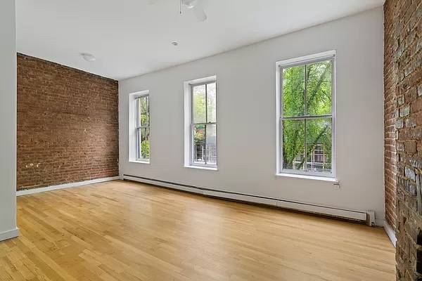 This bright studio apartment has gleaming hardwood floors and nearly 10' ceilings.