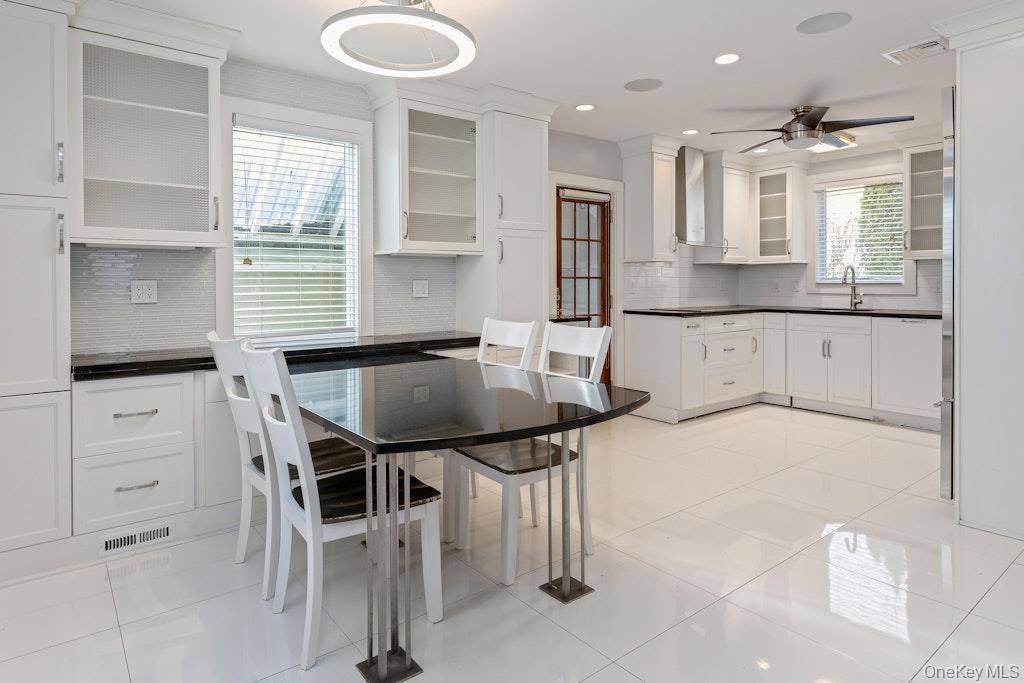 This beautiful Colonial home features an open floor plan kitchen equipped with premium Miele appliances and a Sub Zero refrigerator.