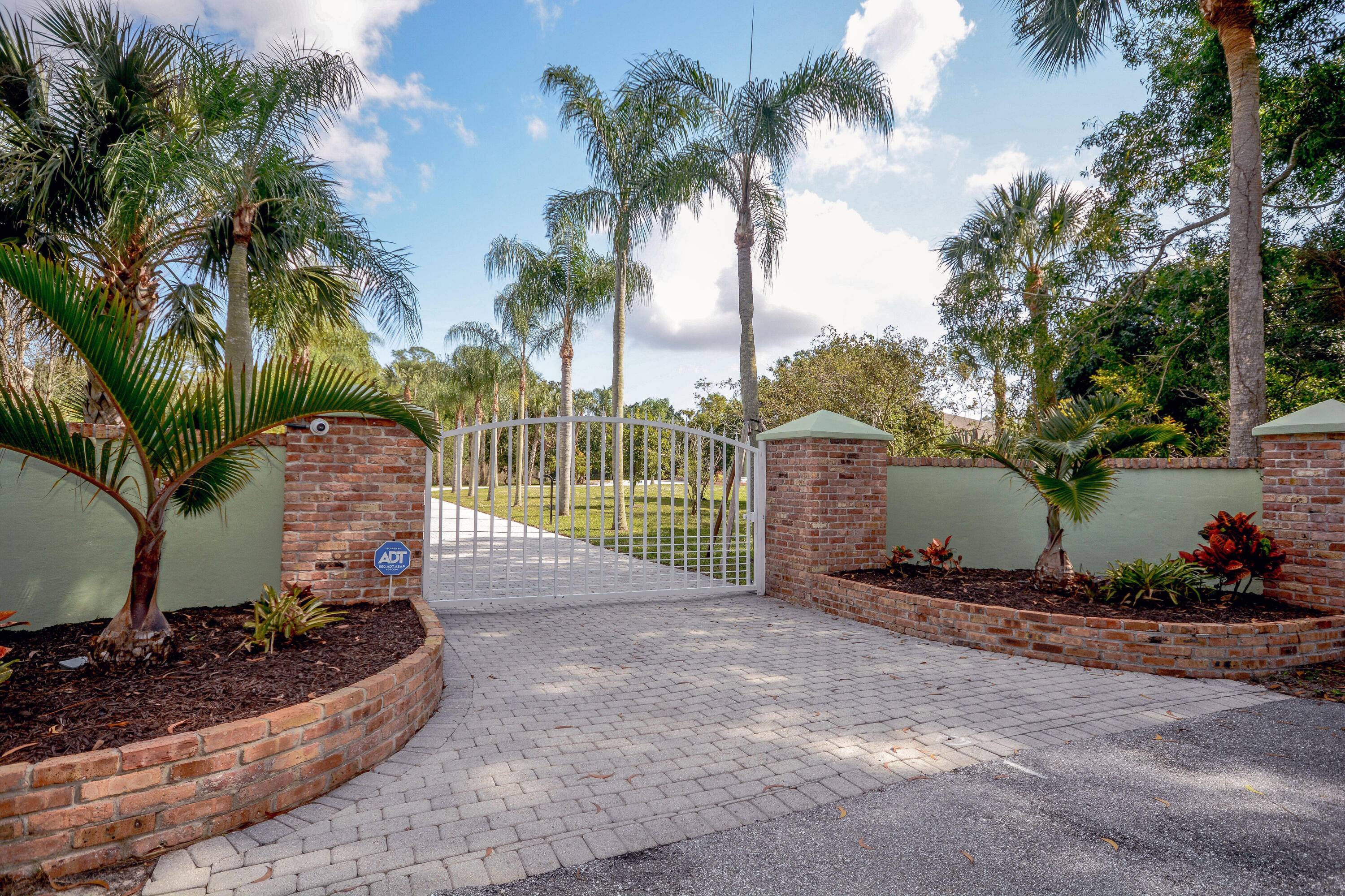 As You Arrive at This 2. 5 Acre Jupiter Farms Property, You Will Be Welcomed Thru a Stately Gated Brick Entry Down the Palm Tree Lined 250' Paver Drive into ...