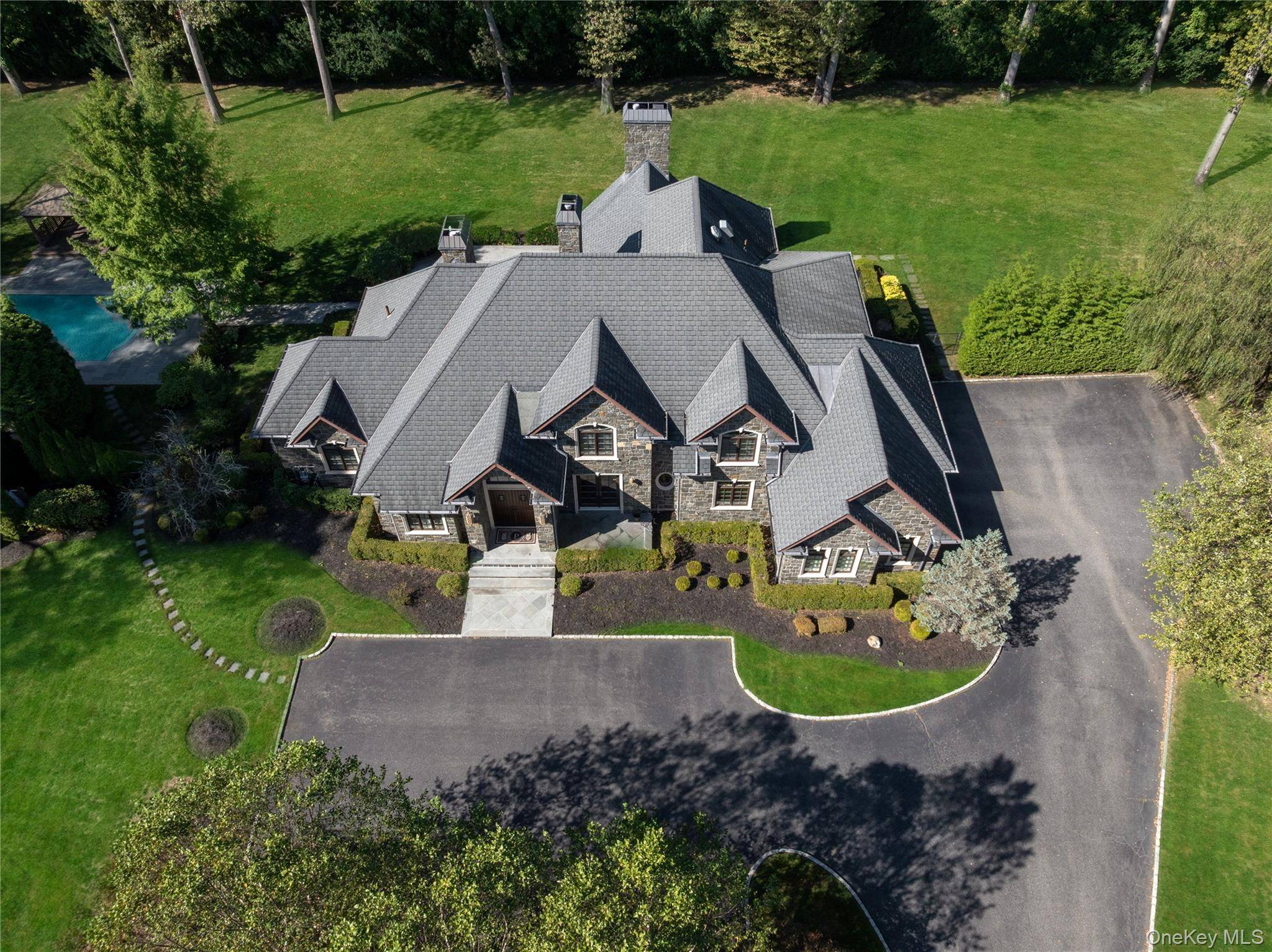 Perfectly situated on over two acres in the heart of Brookville, this stately stone residence combines classic European architecture with modern comfort.