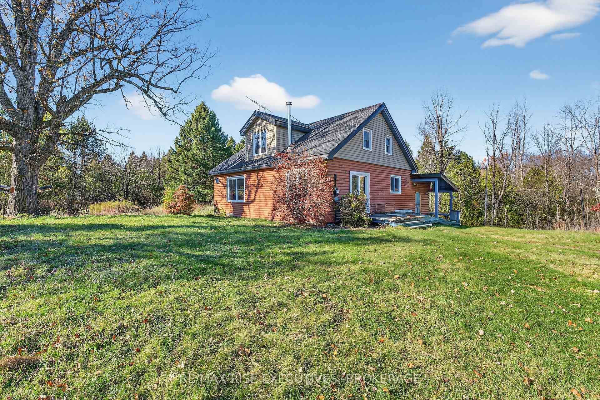 Nestled amidst the trees sits this attractive wood chalet style home with exposed beams on 7.