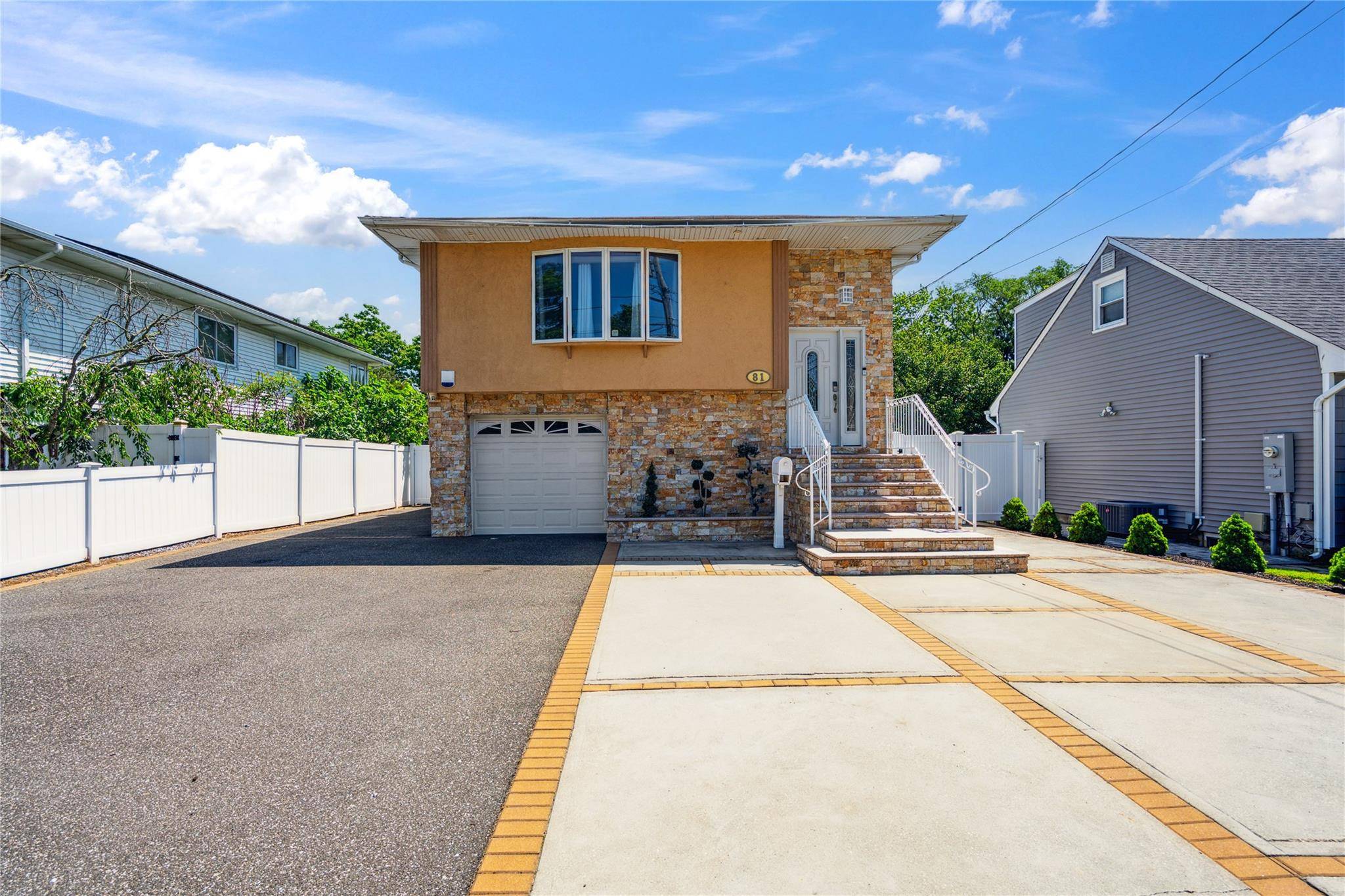 Beautifully maintained home featuring a huge driveway and granite steps leading to the front door.