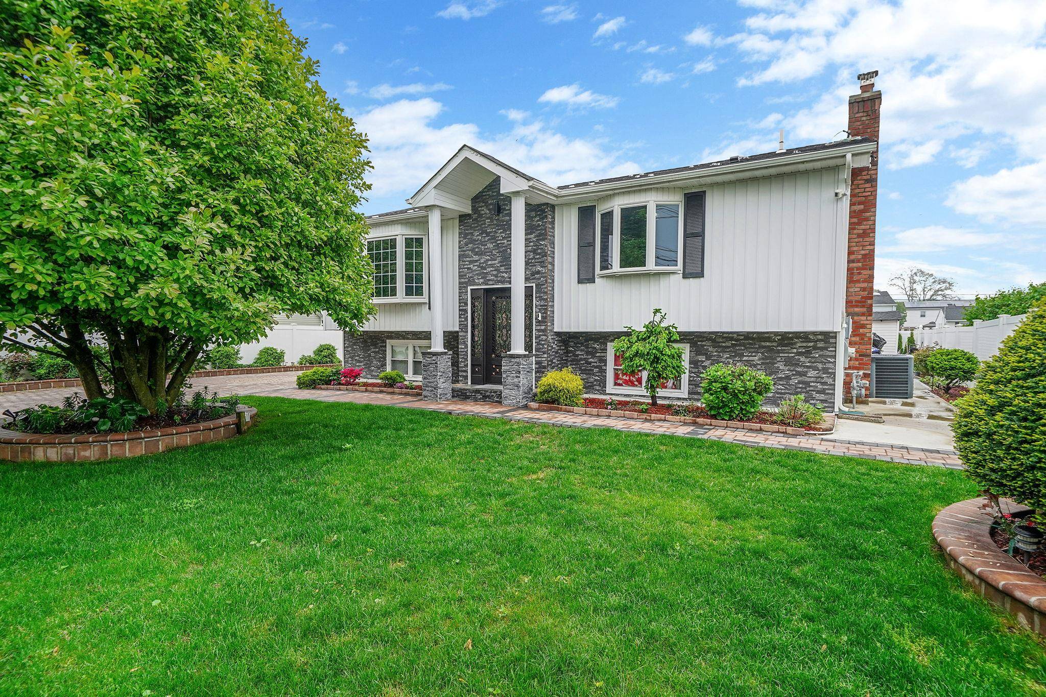 Discover this oversized and fully functional 8 bedroom, 5 bathroom multifamily home, ideally situated in a peaceful and charming neighborhood just one block from Sunrise Highway.