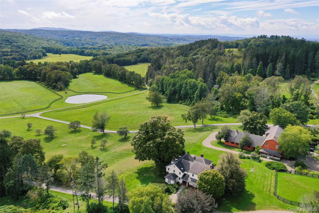 Perched above the bucolic rolling hills of Millbrook Hunt Country, framed by panoramic views of the Catskill mountains sits an idyllic country retreat and extraordinary equestrian estate encompassing 185 ultra ...