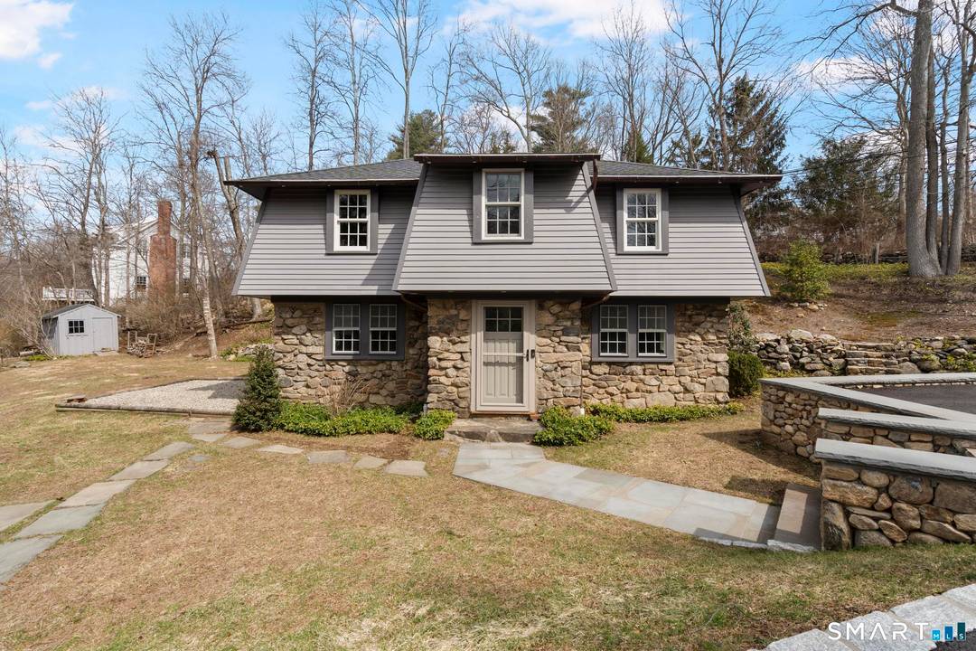 Charming clapboard stone home with idyllic gardens and outdoor living.