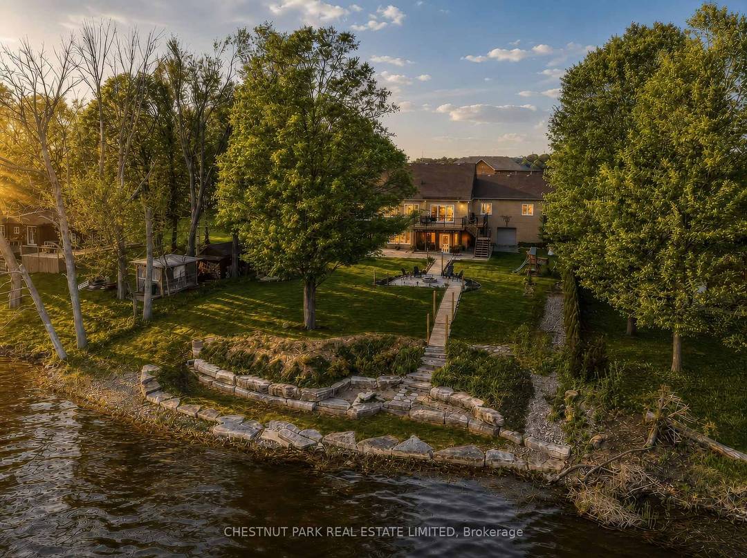 Experience luxury lakeside living in this immaculate waterfront bungalow with 100 feet of private shoreline and breathtaking sunset views across the lake.