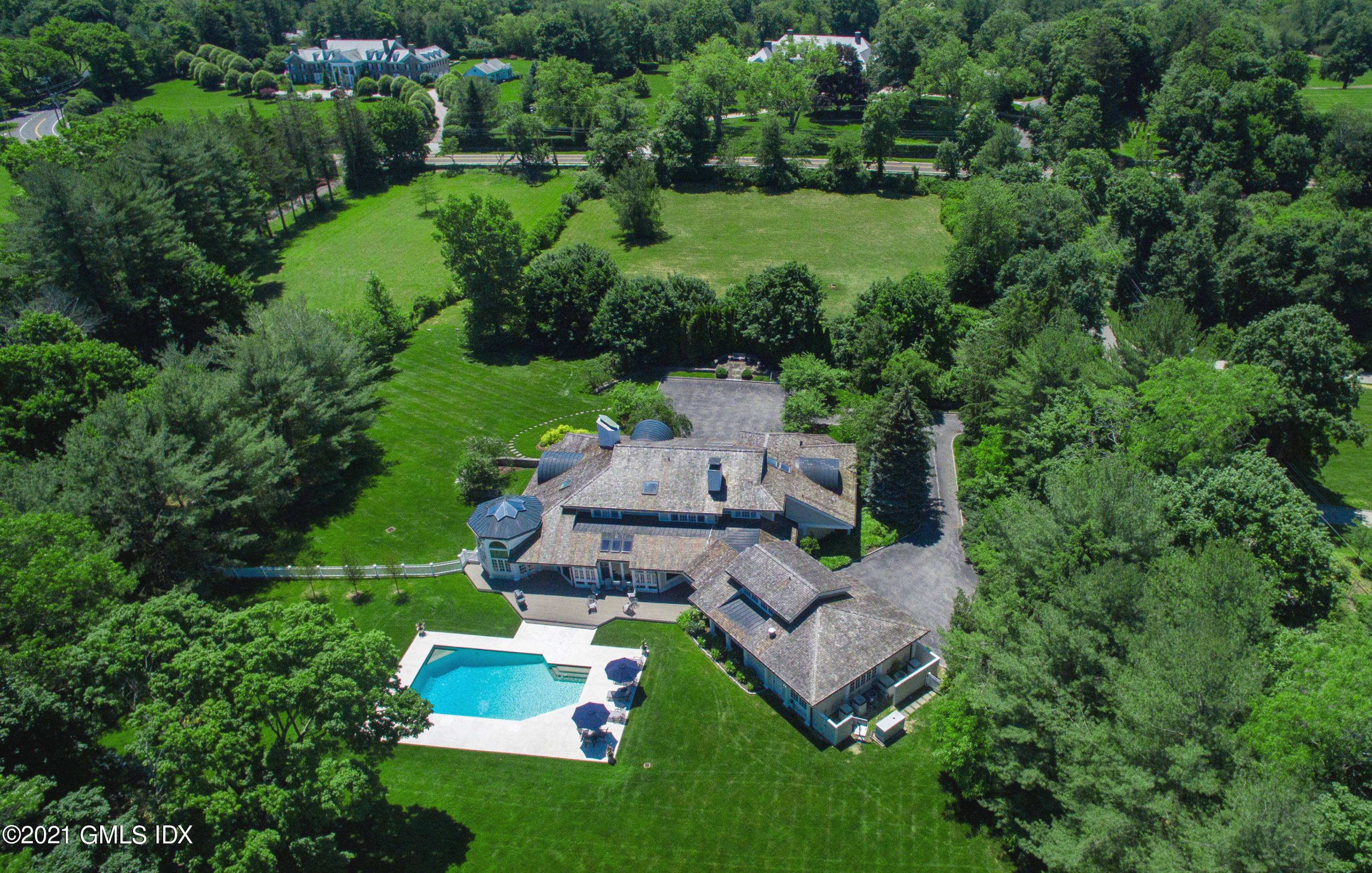 Superbly renovated six bedroom Home presides over four gated, landscaped acres with sensational wraparound porch, entertaining deck and pool off coveted Round Hill Road.