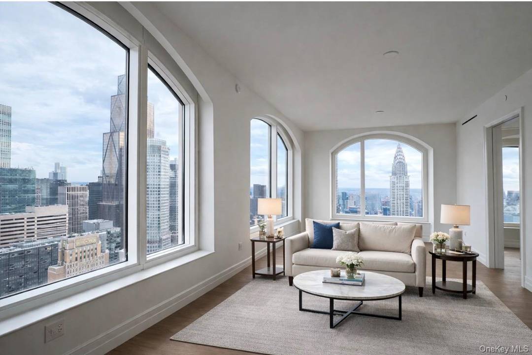 High above Midtown, the 520 5th Ave unit 55B residence showcases dramatic open views of the iconic Chrysler building and One Vanderbilt through oversized arched windows.