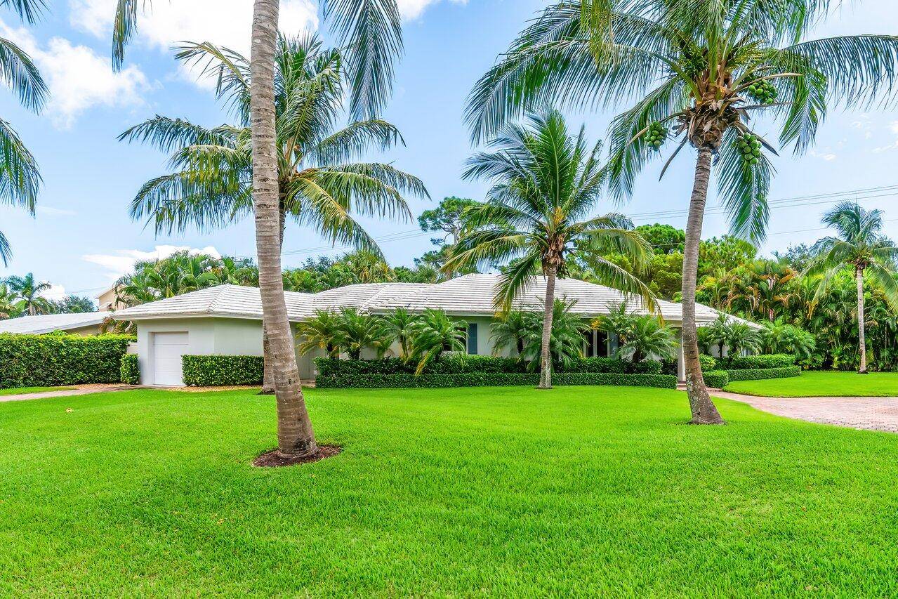 Nestled in a serene and expansive Lake Ida setting, this timeless Bermuda style single level home exudes tranquility and luxury.