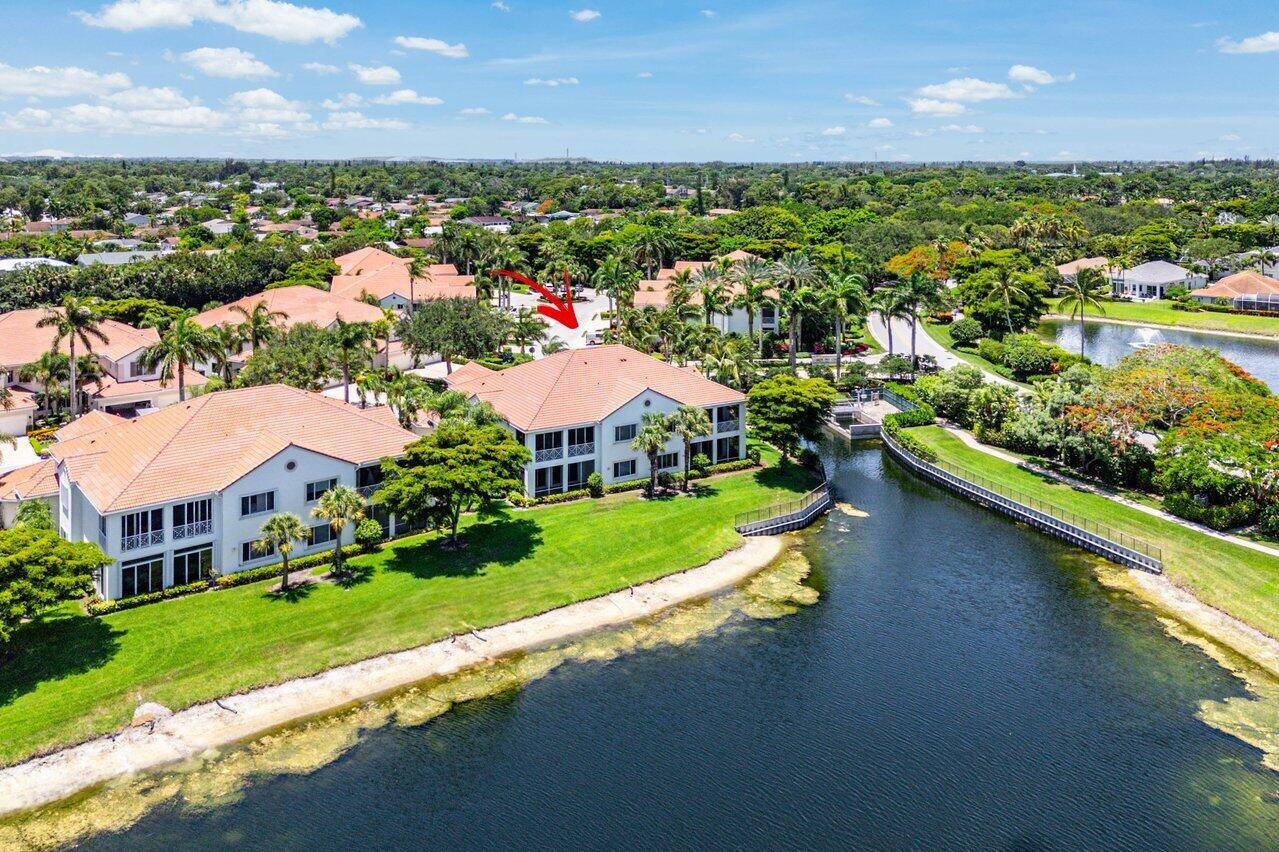 Experience the ultimate in luxury and privacy in this beautifully maintained 1st floor end unit in the exclusive Palm Bay Club at BallenIsles Country Club.