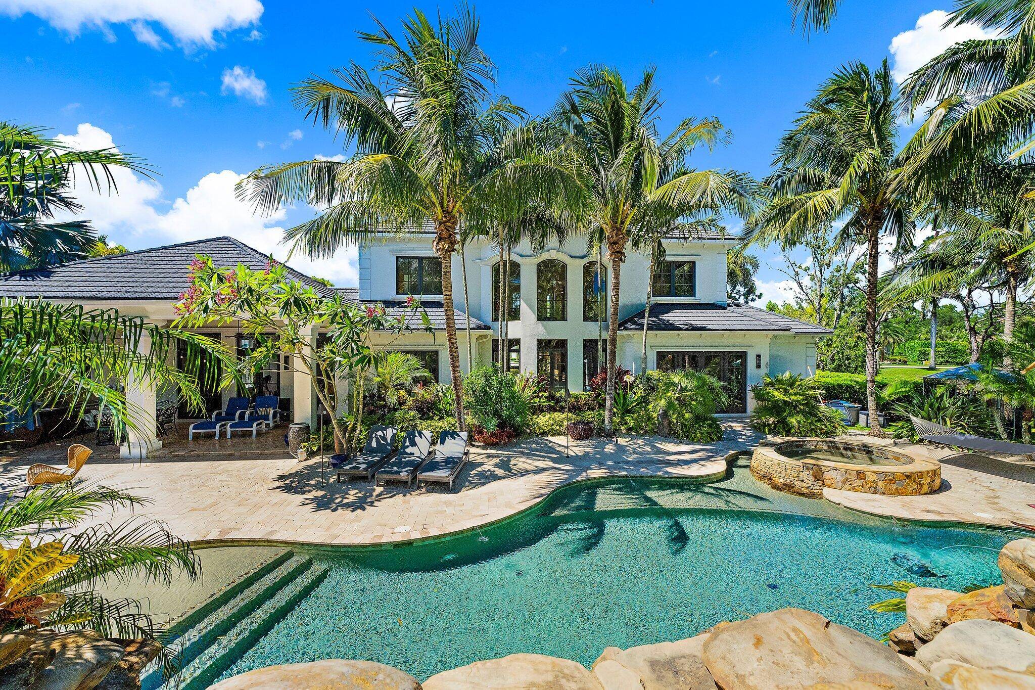Live the resort lifestyle every day in this extraordinary custom estate in the gated community of Jupiter Equestrian Estates Hidden Bridge.
