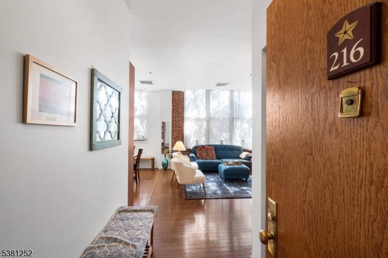 High ceilings and expansive windows define this two bedroom residence at The Mill, where natural light draws attention to exposed brick, hardwood floors, and the seamless flow of the main ...