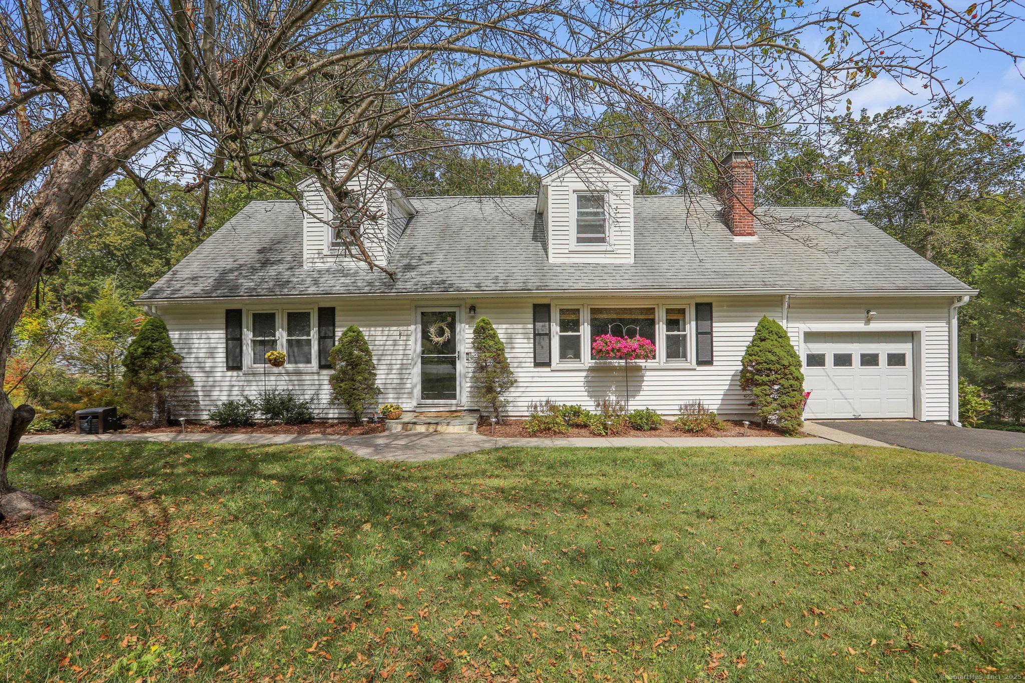 Updated Cape set on a picturesque, park like property with stonework, perennial gardens, and classic stone walls.