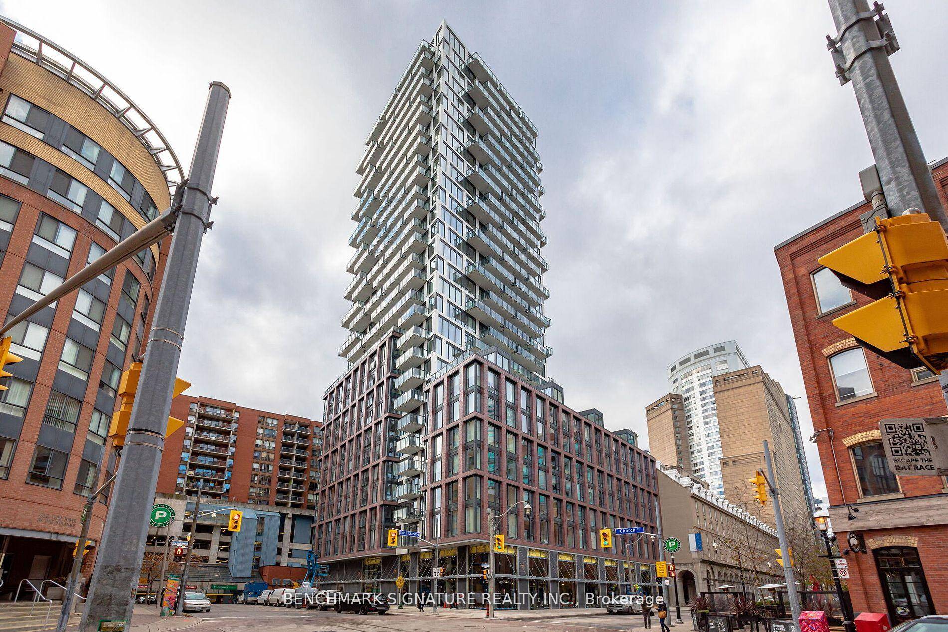 Bright 1 bedroom suite featuring large windows, a modern kitchen with integrated appliances, and convenient in suite laundry.