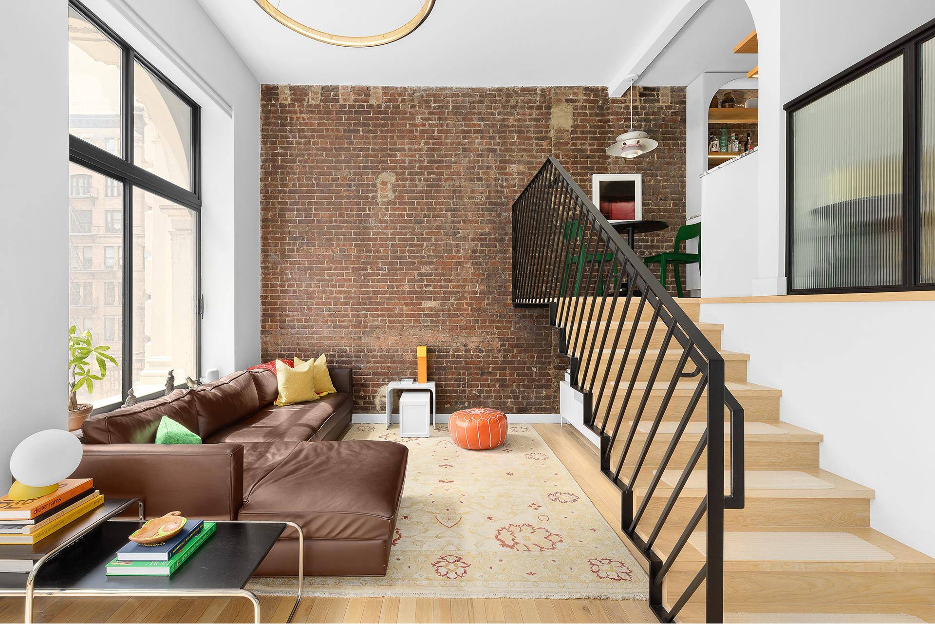 Upon stepping into this exquisite designer duplex loft, you'll be welcomed by an entry foyer adorned with arched doorways, a nod to the building's rich history.