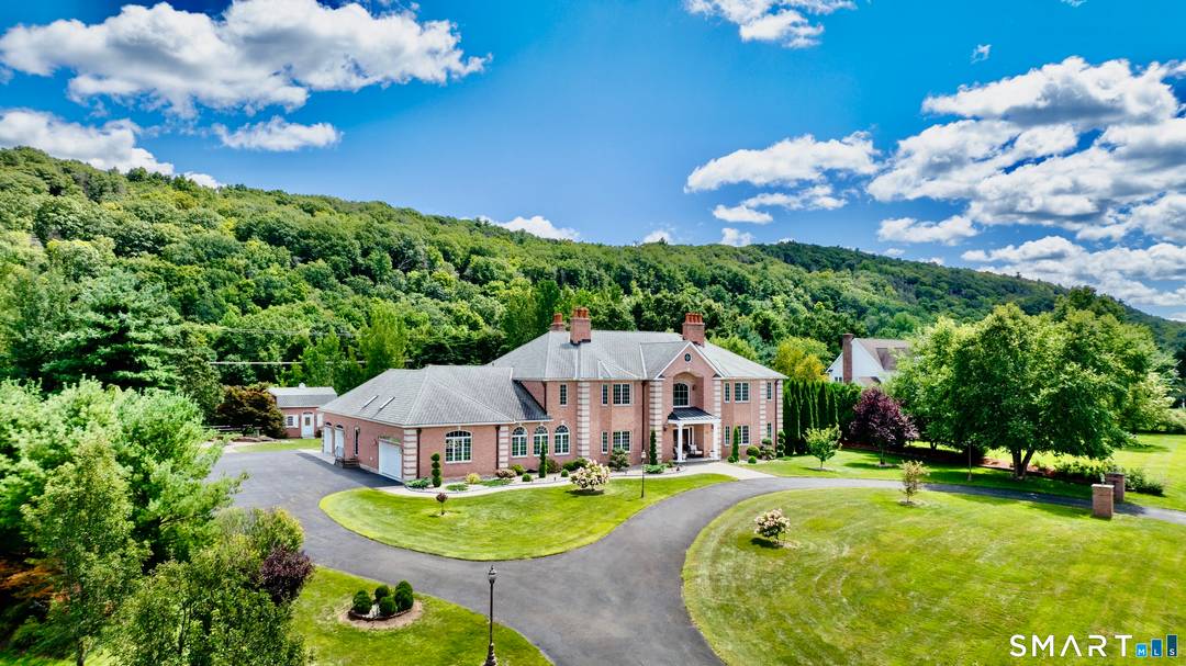 This stunning brick Colonial sits atop Hunting Ridge Drive on a sprawling two acre level lot, offering panoramic views of the Farmington Valley and breathtaking sunsets.