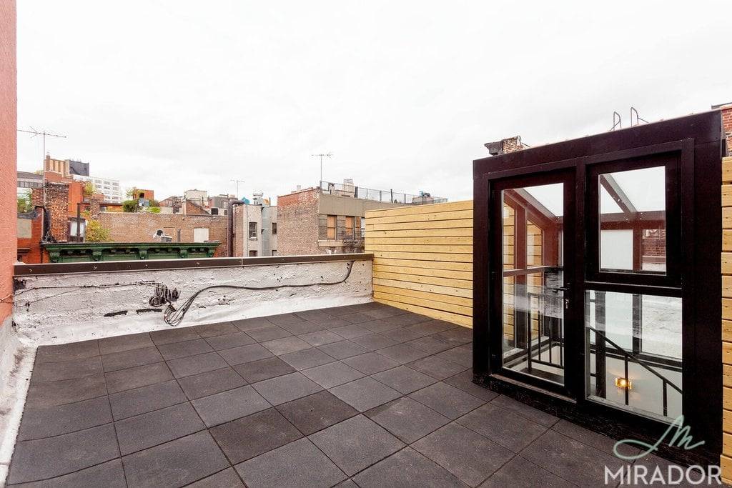 A massive private roof deck sits atop this airy alcove studio in a prime SoHo location.