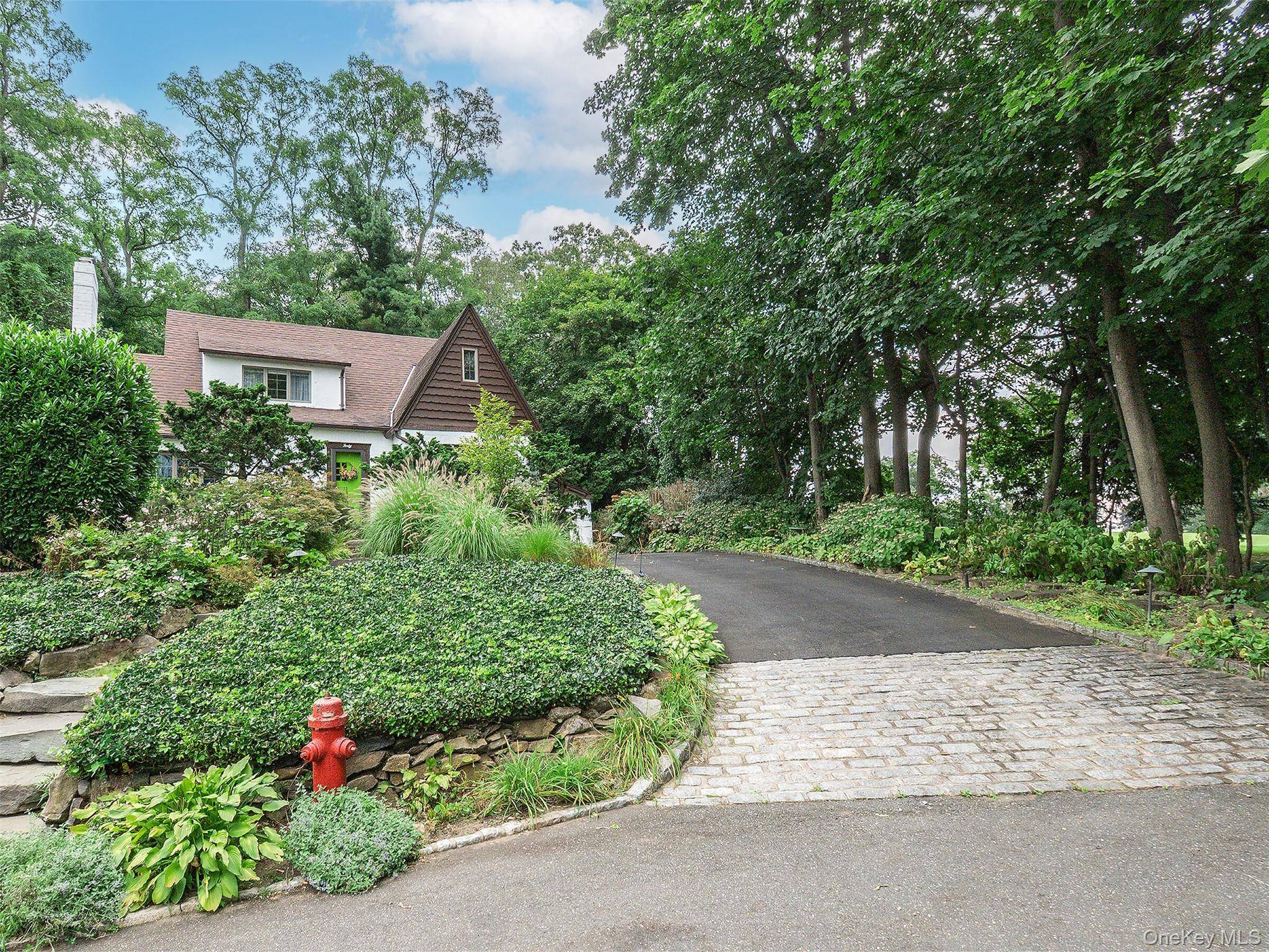 English Tudor surrounded by charming gardens in Manhasset Bay Estates.