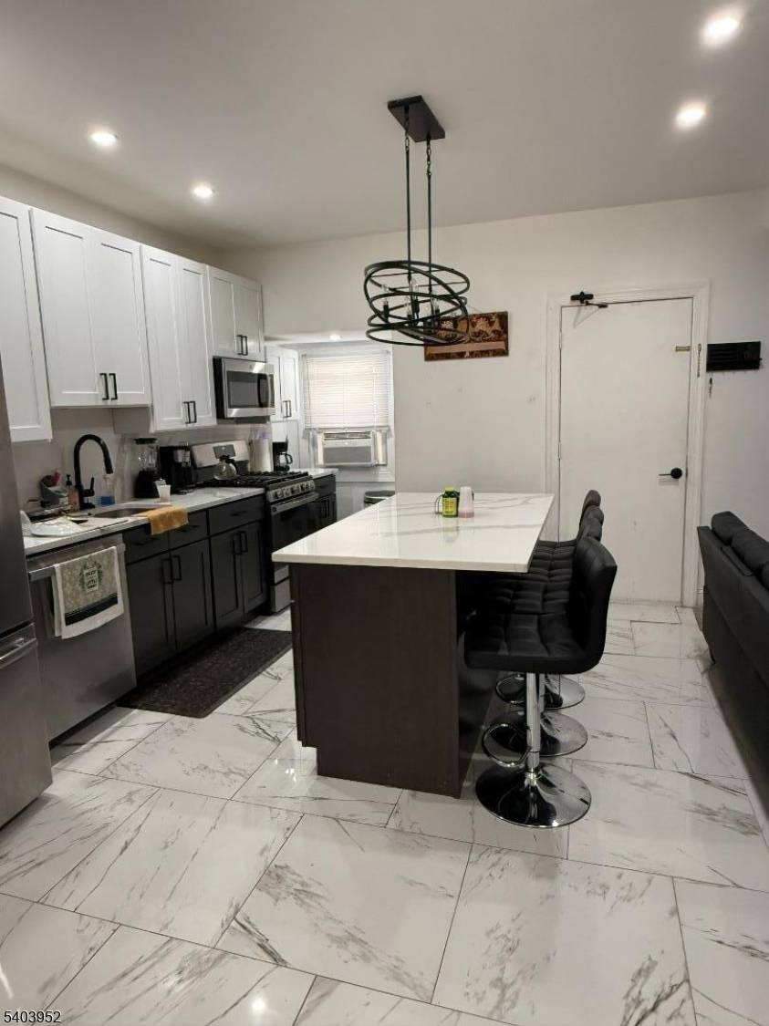 This Beautiful Three Family Home Offers an open concept modern kitchen with quartz countertops, stainless steel appliances, plenty of natural sunlight, Living room, two bedrooms, and one full bath, all ...