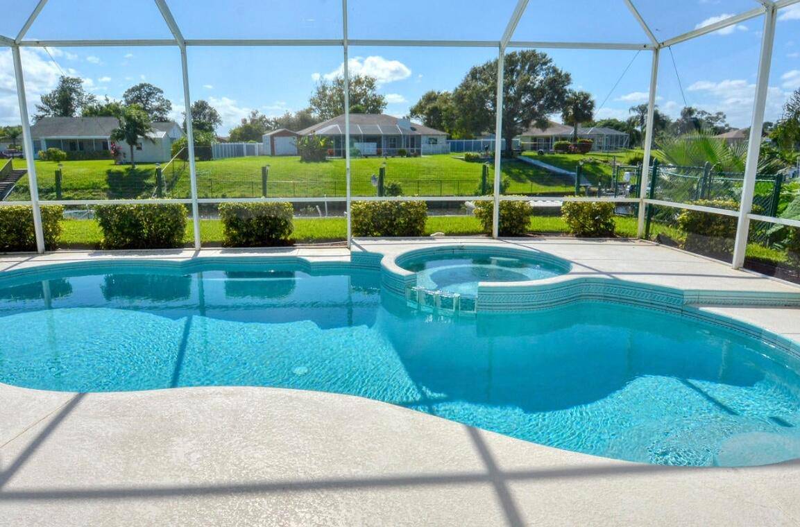 A private boat dock, equipped w lift protective boat cover, extends seamlessly into the tranquil canal, granting access to the open ocean.