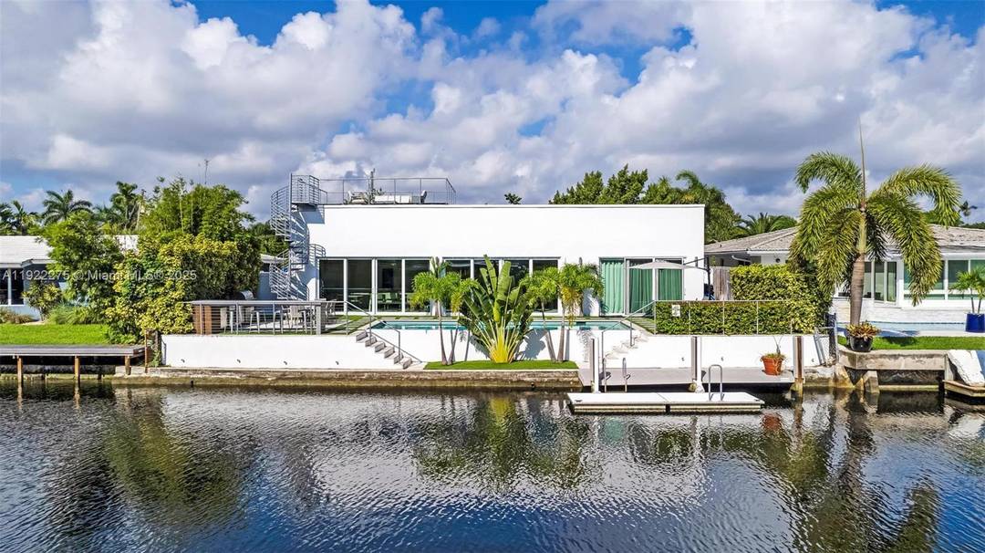 Hidden behind a majestic century tree, this Wilton Manors waterfront masterpiece delivers an unforgettable wow the moment you step inside.