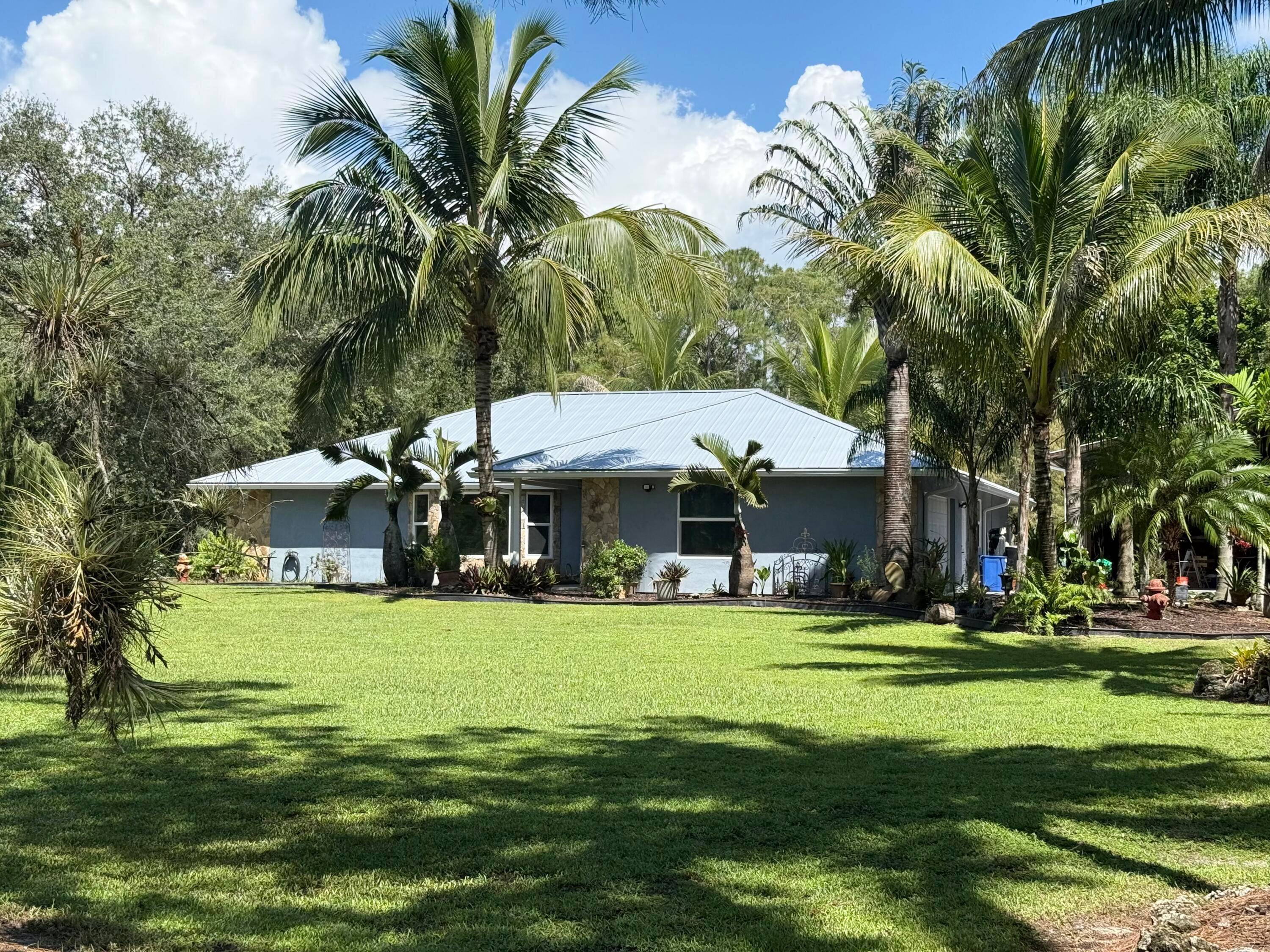 Welcome to your modern chic country retreat in Jupiter Farms a peaceful, no HOA community known for its equestrian and agricultural lifestyle.
