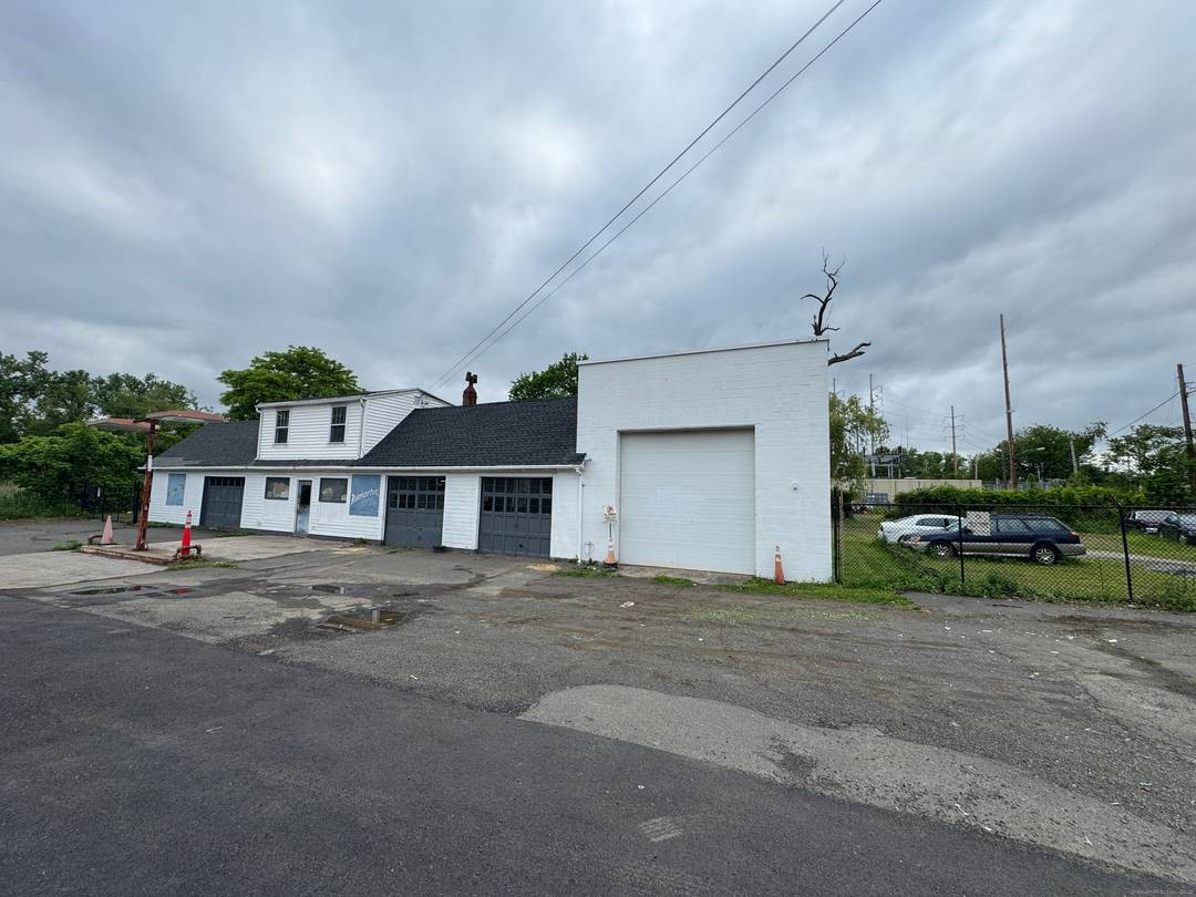 This property, formerly a gas station, is currently being utilized as an auto repair shop and used car dealership.