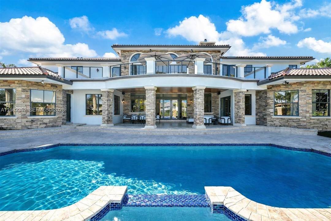 Weston s premier trophy estate, set on a coveted corner lot with exceptionally rare and expansive waterfrontage in the prestigious guard gated community of Windmill Ranch.