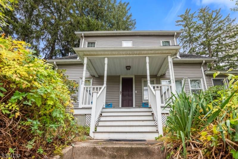 Beautifully maintained charming Cape Cod, perched gracefully above the road with an inviting open covered front porch.