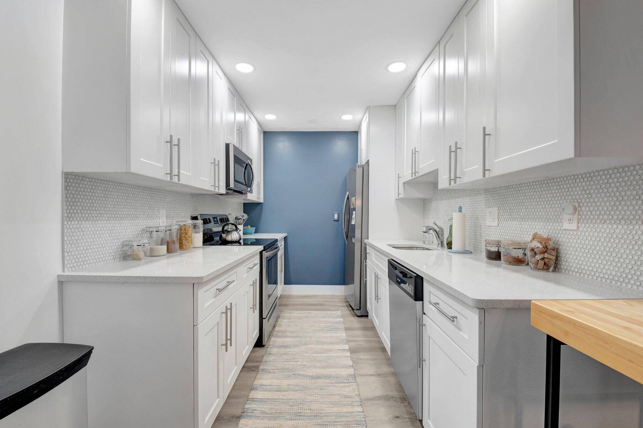 This updated villa features modern white Shaker style kitchen cabinets and quartz countertops with stainless steel appliances, renovated bathrooms and beautiful laminate flooring throughout.