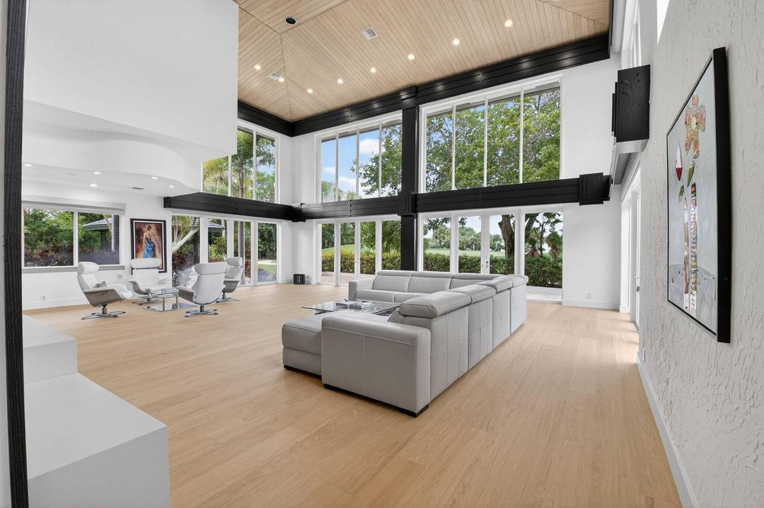 Experience unparalleled luxury in this custom estate situated on a premier double golf view lot in Oakbrook at Boca West.