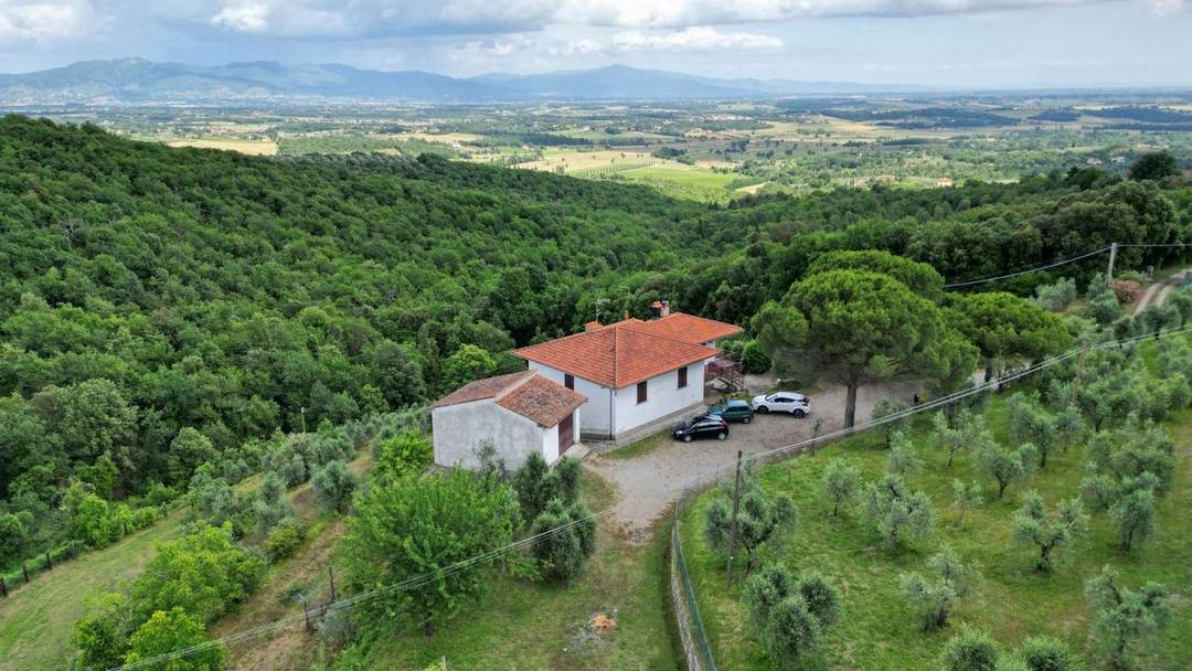 Property consisting of a villa, two outbuildings and 5.4 hectares of land with olive grove, vineyard, arable land and woodland for sale in Civitella in Val di Chiana, Tuscany.